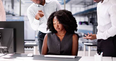 Woman annoyed by men at work - Hostile Work Environment